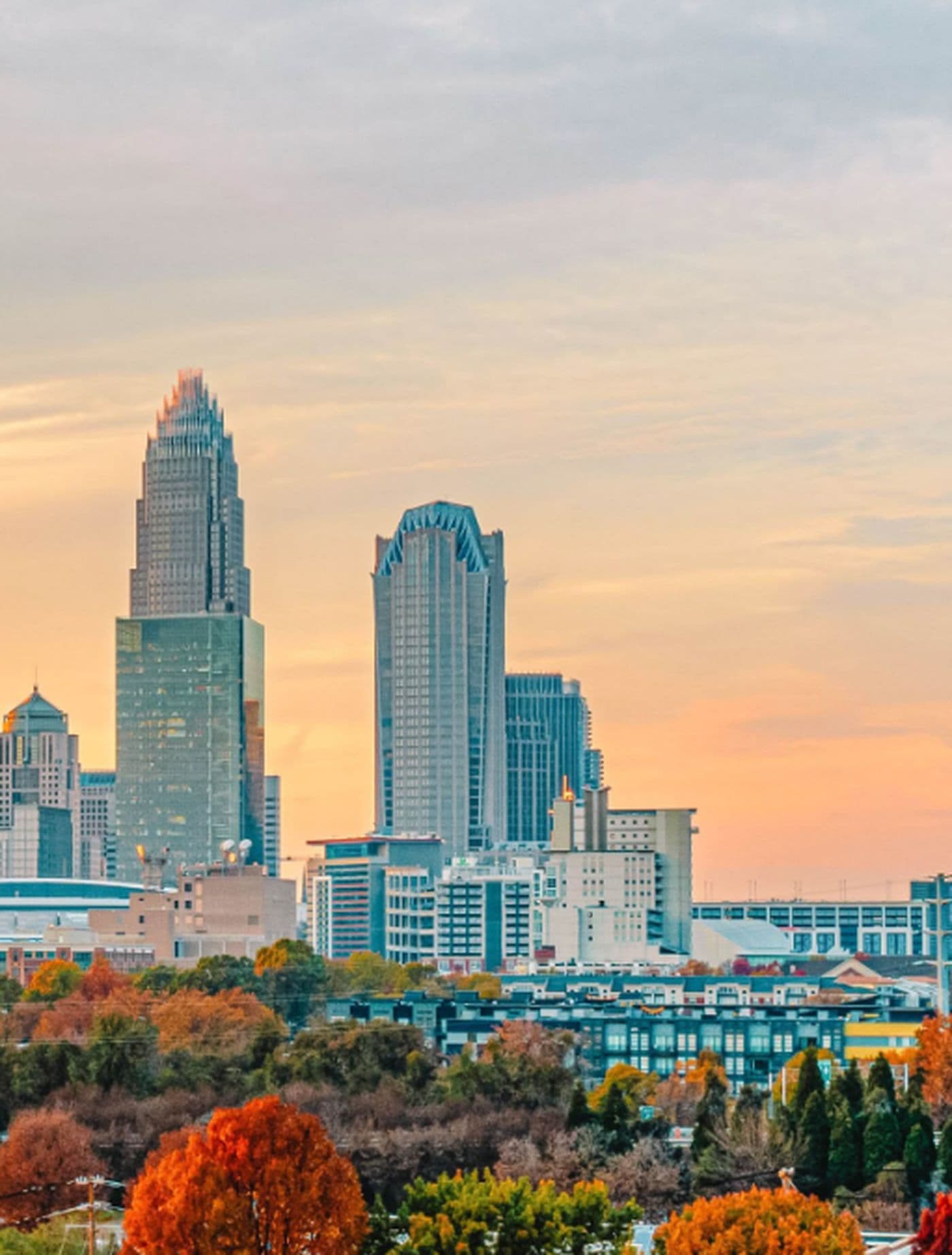 Downtown Charlotte, North Carolina skyline at sunset with autumn trees in the foreground